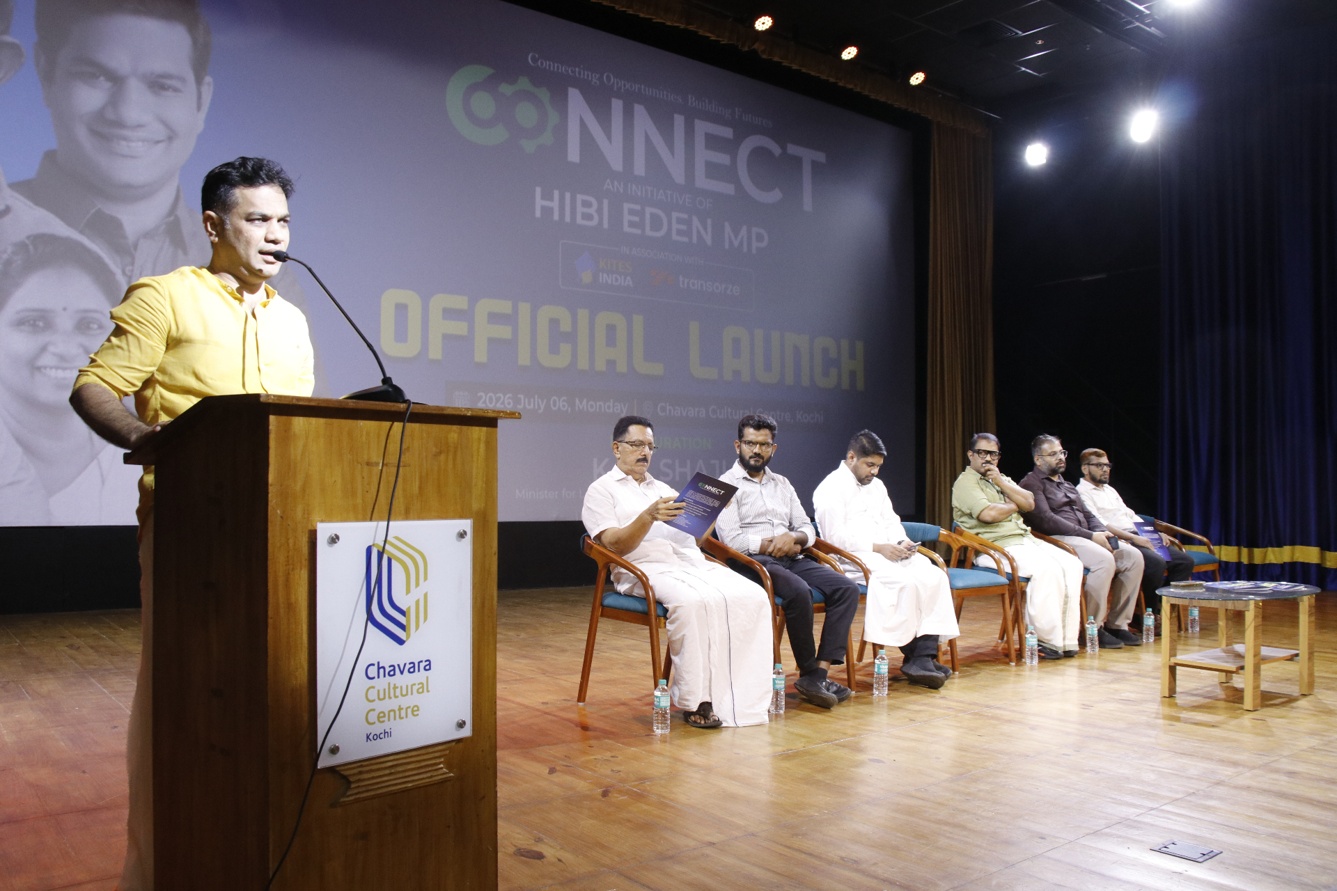 Speaker at the podium during the CONNECT official launch with dignitaries seated on stage